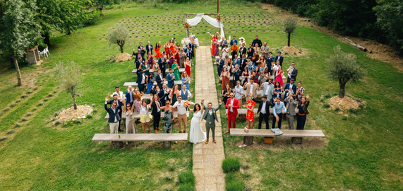 Un mariage en plein air avec les mariés et de nombreux invités.