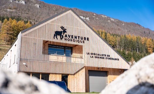 Façade de Aventure Nordique: texte et logo, montagnes en arrière-plan à l'extérieur.