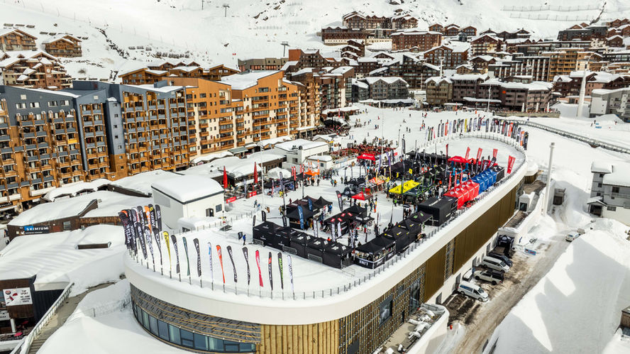 Vue aérienne d'une station de ski avec bâtiments et skieurs dans la neige.