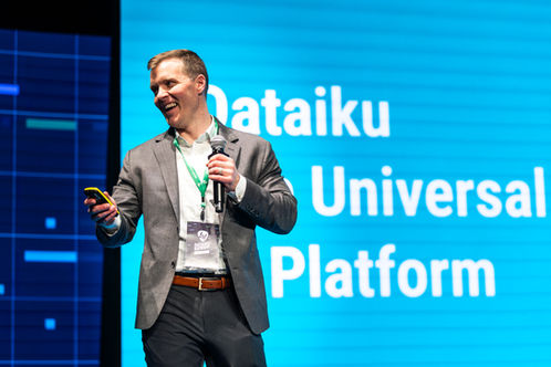 Un homme présente avec un microphone devant l'écran 'Dataiku Universal Platform'.