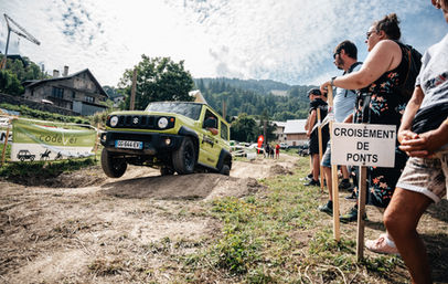 Véhicule jaune franchissant une petite butte avec le signe 'CROISEMENT DE PONTS'.