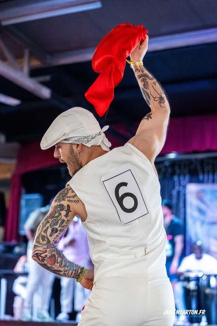 Man holding up red cloth with number six on his back