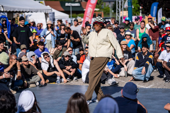 Danseur performant devant une foule, scène de spectacle en plein air.