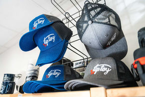 Tip Toy hats on display, blue and grey caps, logo presented publicité.