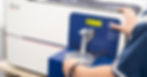 Quality control technician operating spectrometer for alloy verification - ISO Standard