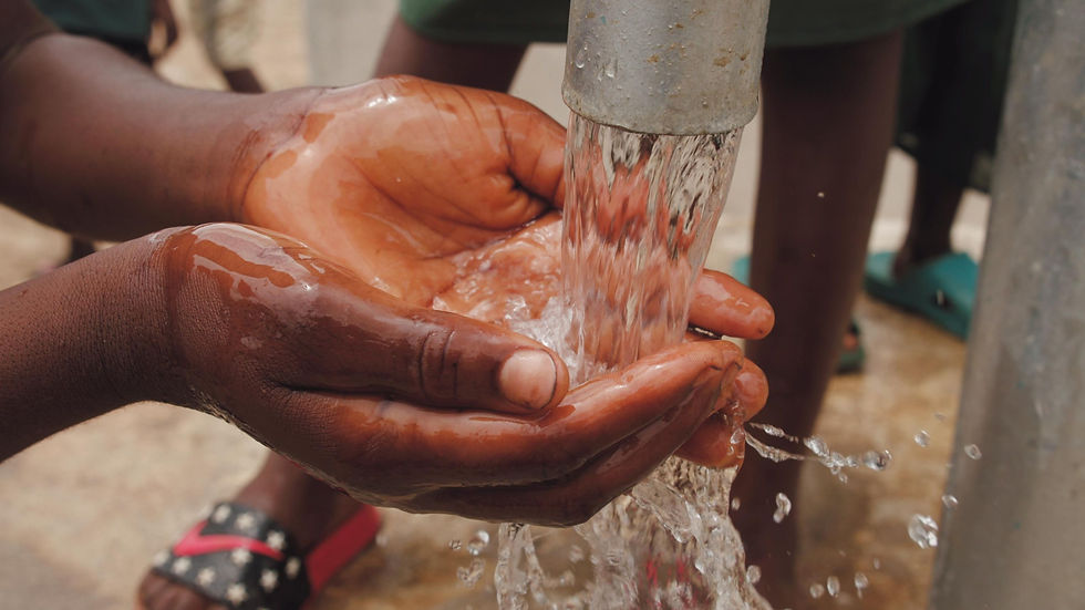 Hand of a person cupping the clean water flowing from an artesian well. 