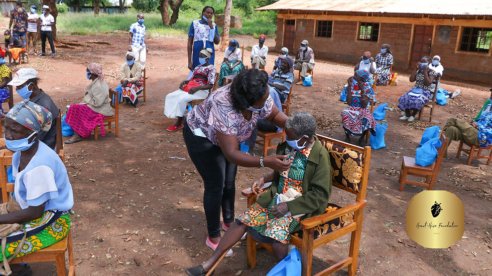 Black elderly people sitting on chairs in yard of hospital in poor African village