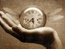 Antique photo of hand holding a clock with insect wings