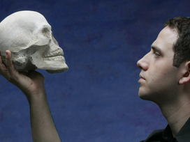 Man holding and looking at human skeleton crane