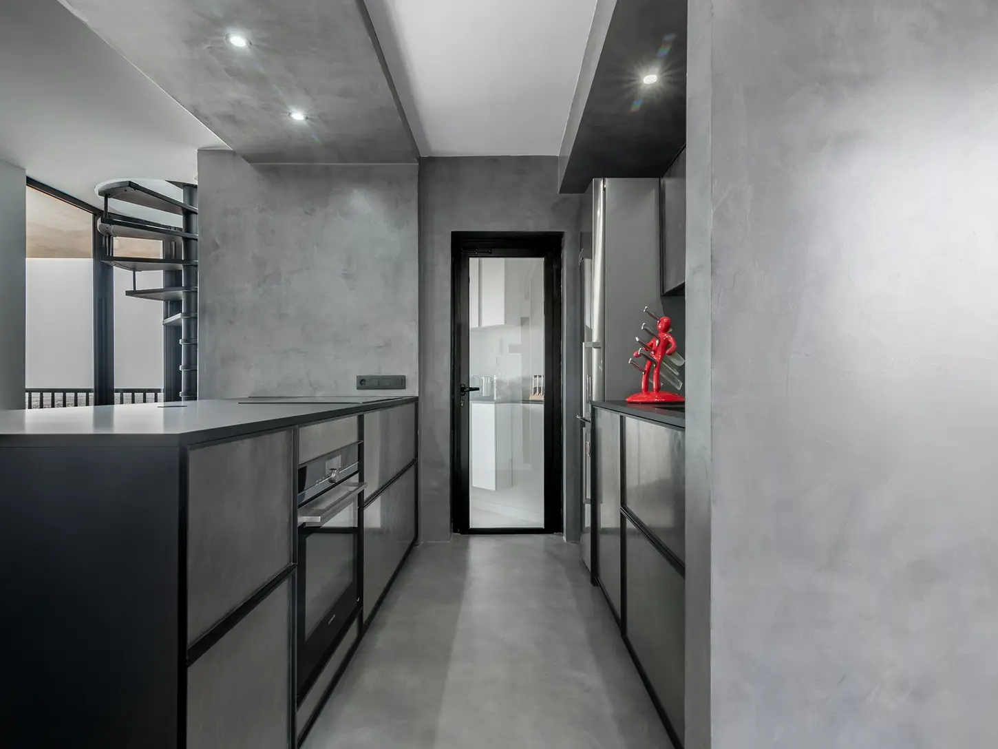 Modern kitchen with dark finishes and linear development along the corridor