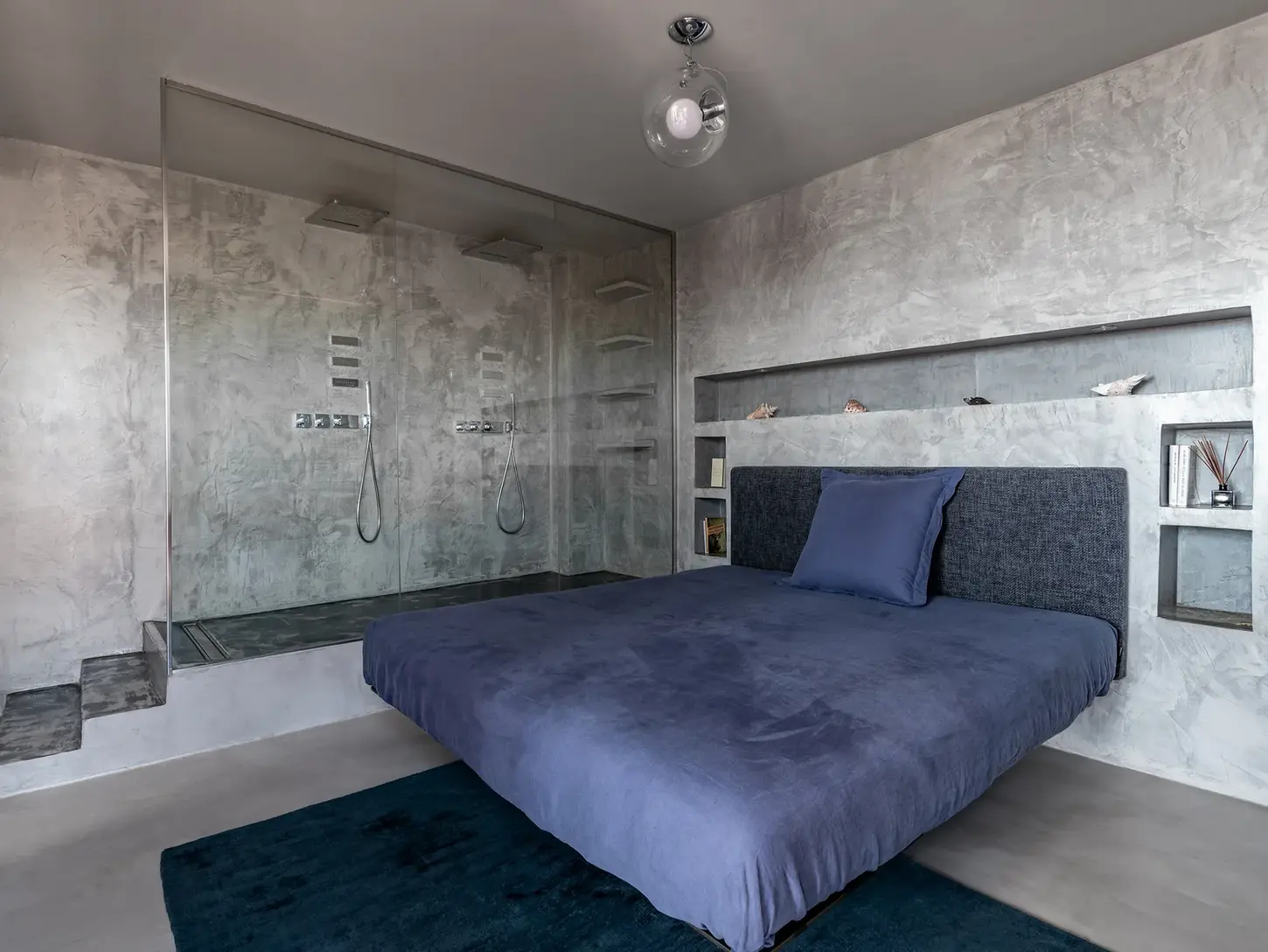 Master bedroom with textured concrete-effect walls and a cozy atmosphere