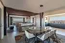 Zona pranzo in open space con tavolo, cucina e vista sugli ambienti, progetto Villa Kendwa a Fuerteventura – H&H Design