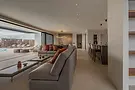 Zona living con divano e cucina a vista in ambiente open space, progetto Villa Delta a Fuerteventura – H&H Design
