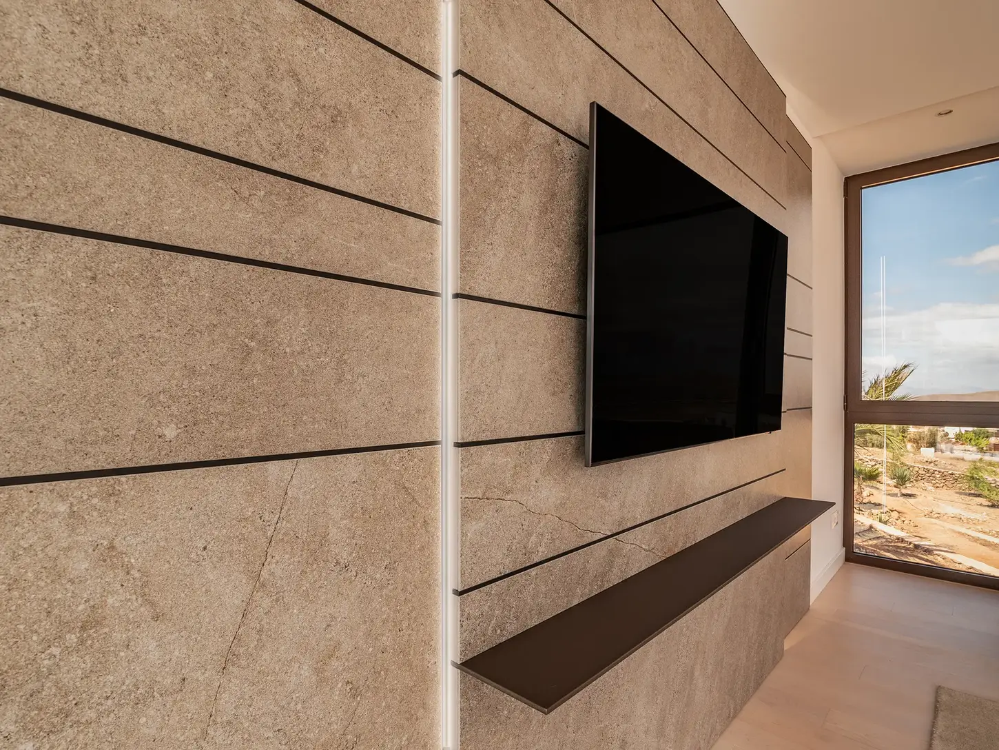 Detail of a TV wall in textured cladding with horizontal cuts