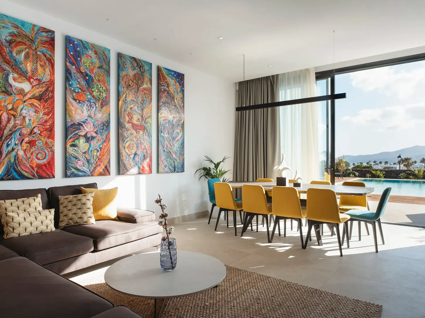 Living and dining area with colorful artwork and modern furnishings