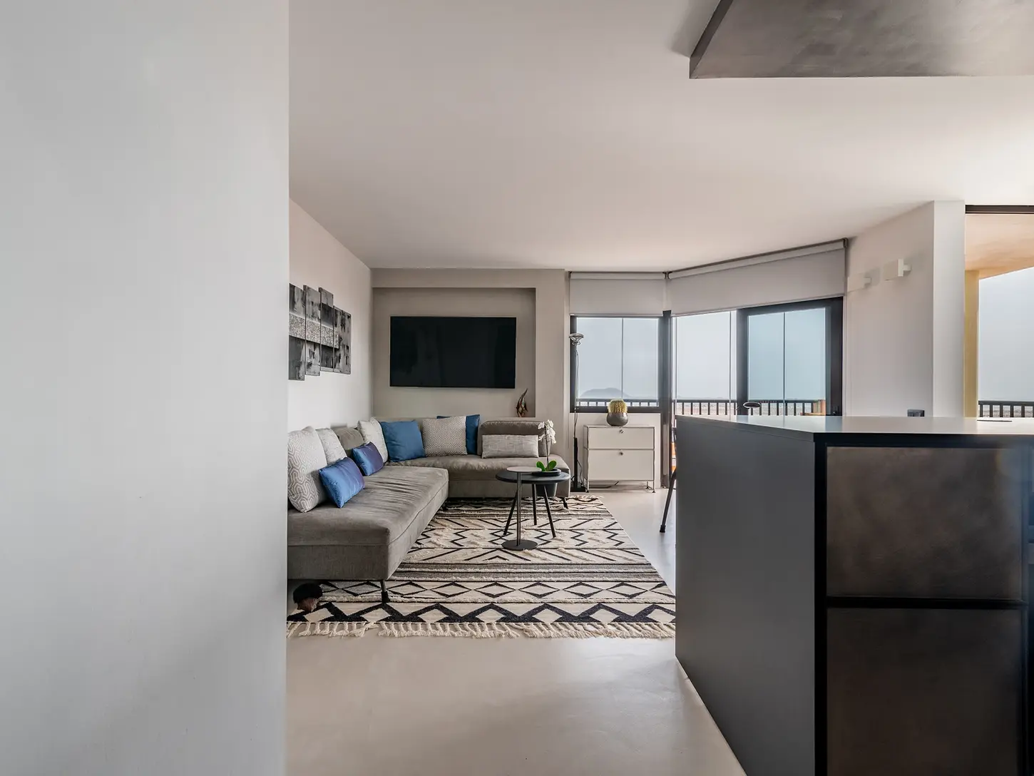 Living room with sofa and dining area in a bright contemporary setting