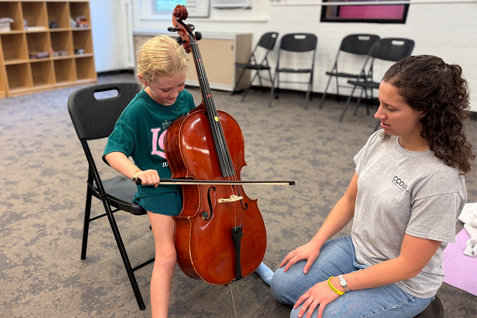 Orchestra teacher Vanessa Hall works with third-grader Ashlyn Willoughby.