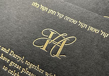 Sophisticated black wedding invitation with a calligraphy monogram hot foiled in gold