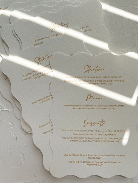 Modern, playful and bespoke white menus with wavy edges letterpress in a latte colour