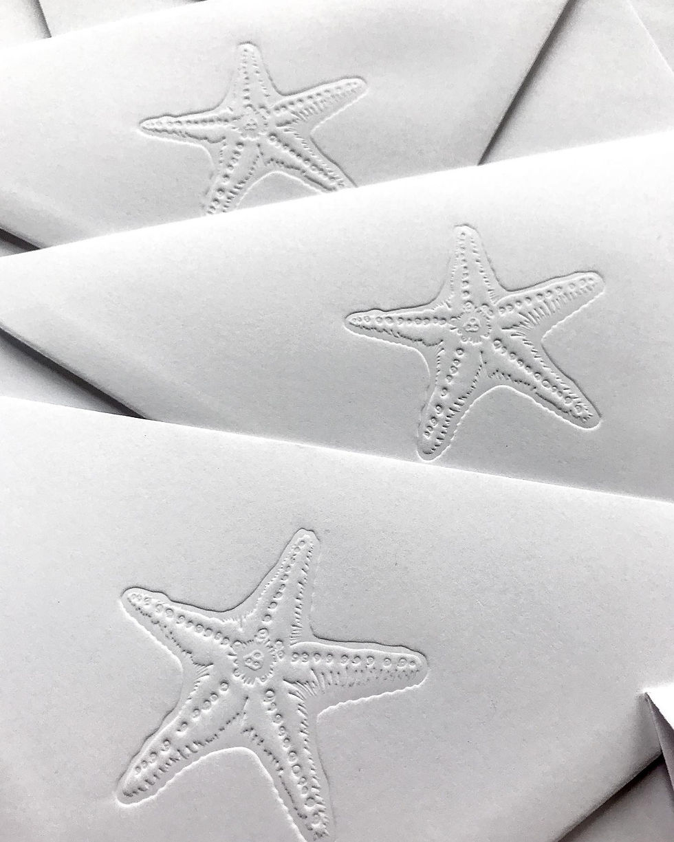 Blind deboss starfish on white wedding envelopes.jpg