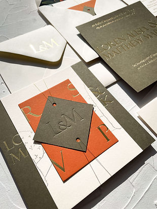 Hot foiled modern invitation suite assembled with gold twine and a blind debossed monogramed tag
