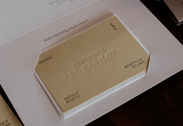 Small blind debossed RSVP card with a mini envelope tuck inside a trifold wedding invitation