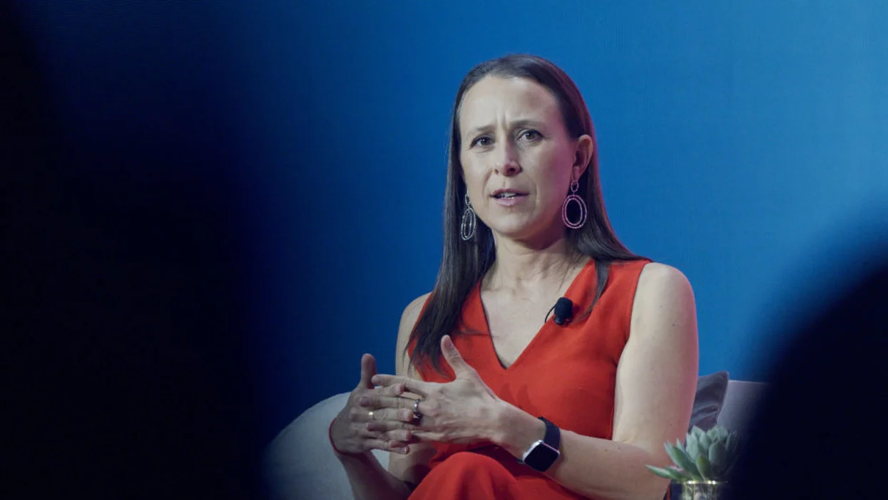 Businesswoman and personality Anne Wojcicki speaking on stage at sit-down speaking event.