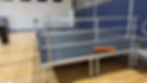 Portable event staging platform with safety rails in a gym.