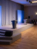 Professional event staging with podiums and custom colored LED lighting.