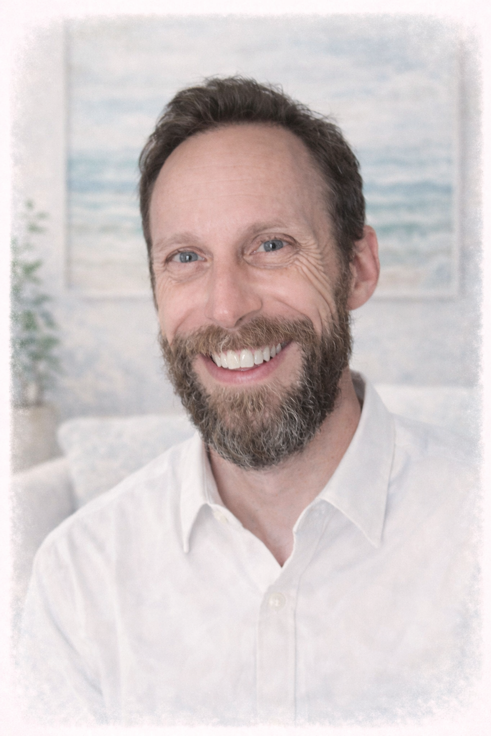 Smiling man in coastal-inspired room.png