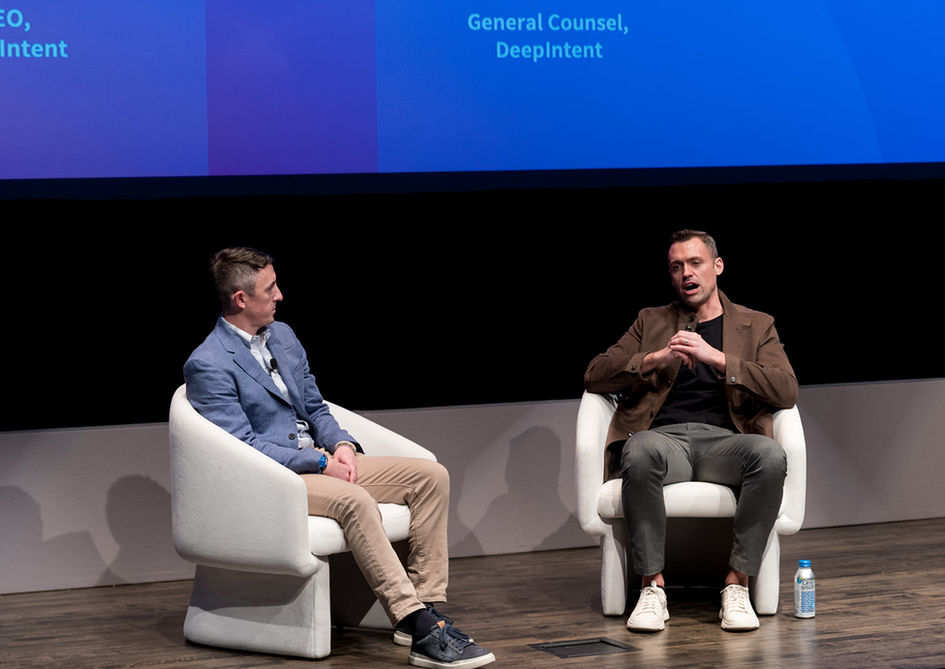 Pharmaceutical industry speaker presenting on stage with branded screen at media conference in New York City
