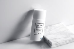 化粧品撮影カメラマンが、柔らかな光の中でトゥヴェールの白いスキンケアボトルをブランド感ある美容写真として撮影。