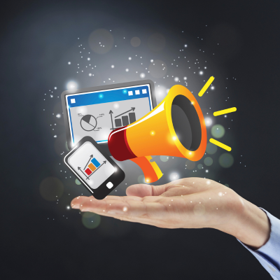 A person with an open palm. On the palm is a cellphone and computer with marketing analytics on it and a marketing megaphone next to them.