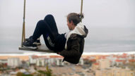 Child thinking while swinging