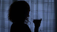 A woman drinking wine in secret.