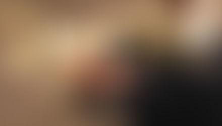 A person in a suit points towards glowing text "Gen X" with floating gears and sparkles on a blurred brown background.