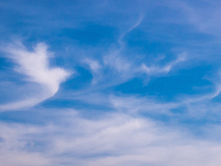 Blue sky with wispy white clouds, creating a calm, airy atmosphere.