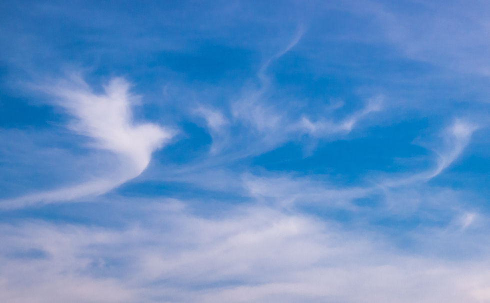 Blue sky with wispy white clouds, creating a calm, airy atmosphere.