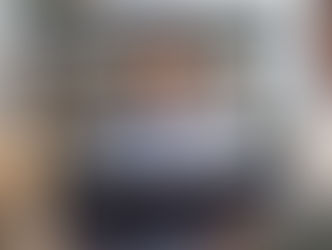 A telehealth call on a laptop screen, showing a counselor in a blue shirt while the client listens.