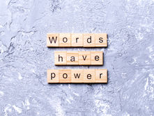 Wooden letter tiles spell words have power on a gray textured background.