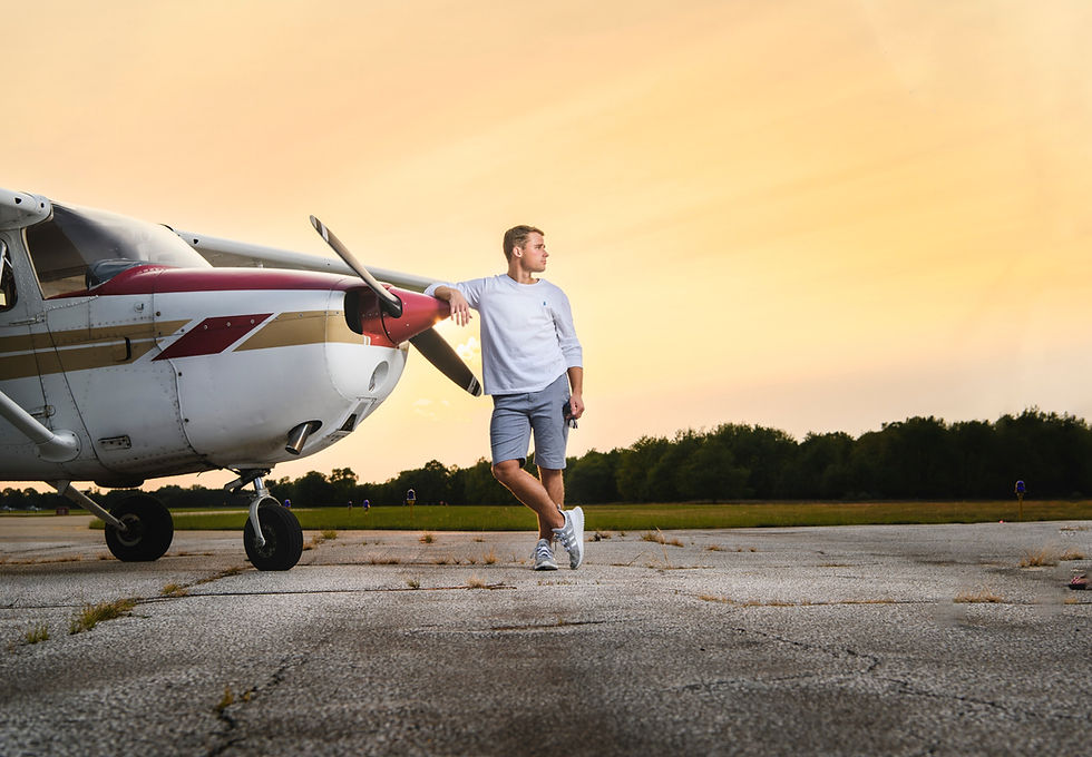 Senior guy stares into setting sun with airplane.