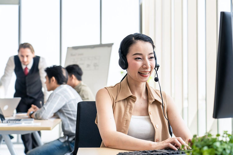 asian-young-call-center-work-with-smile-in-workplace-while-colleague-meeting-and-brainstor