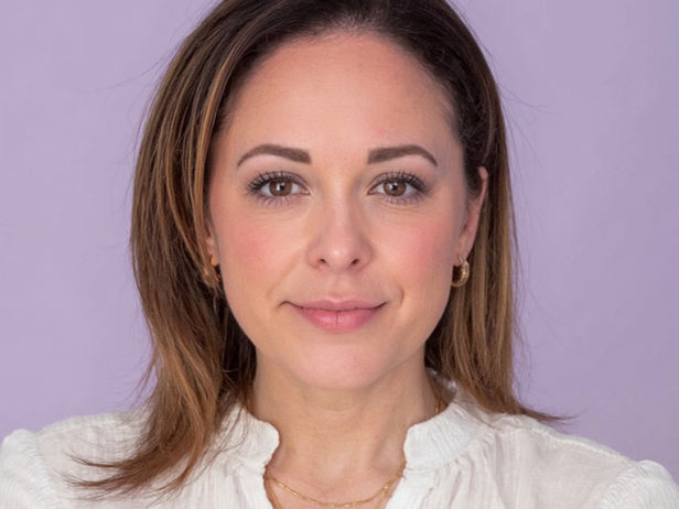 brunette female headshot with pinkish purple background