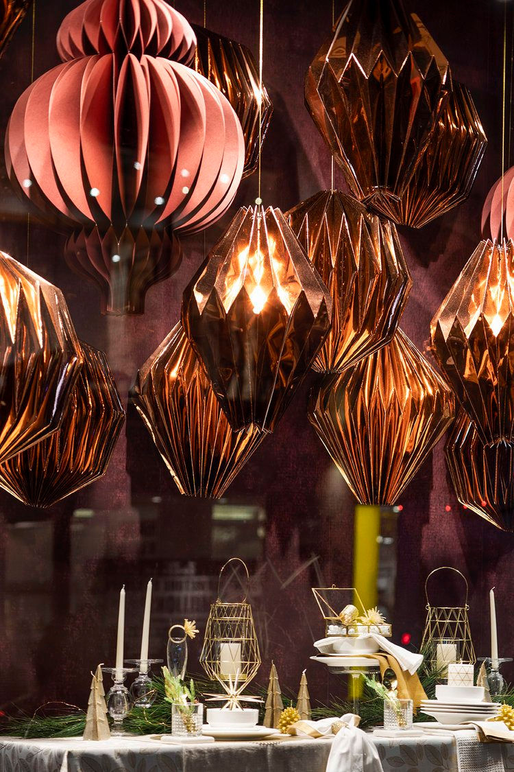 Ornate brown paper lanterns and table setting in a window display, festive decor. uMake Laser Cutting