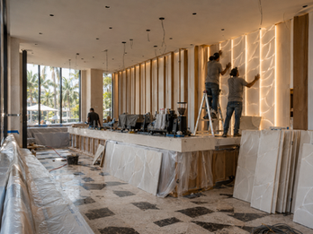 Custom illuminated CNC relief wall and bar front at Antonio Café South Beach featuring organic textured architectural panels with integrated LED lighting.