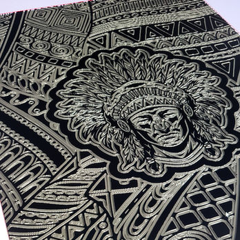 Contemporary sculptural relief featuring an ancestral figure surrounded by intricate cultural patterns and illuminated architectural detailing.