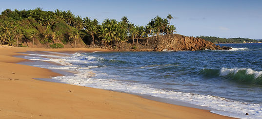 Deserted African beach with sand and rocky coastline at sunset in Axim, Ghana.jpg