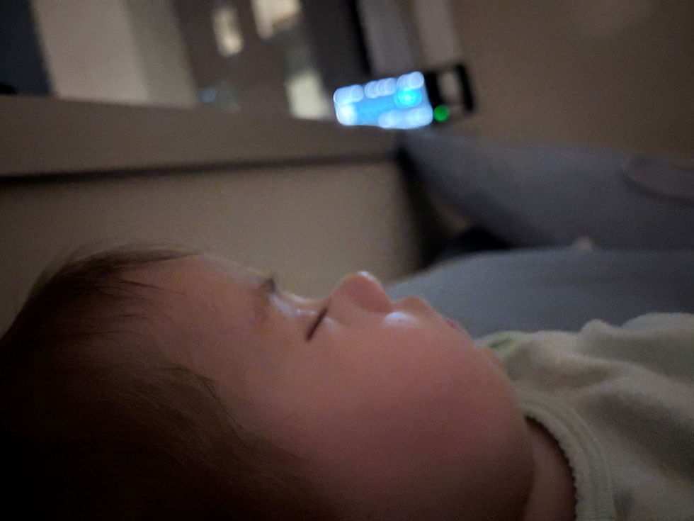 Sleeping baby with a baby monitor in the background