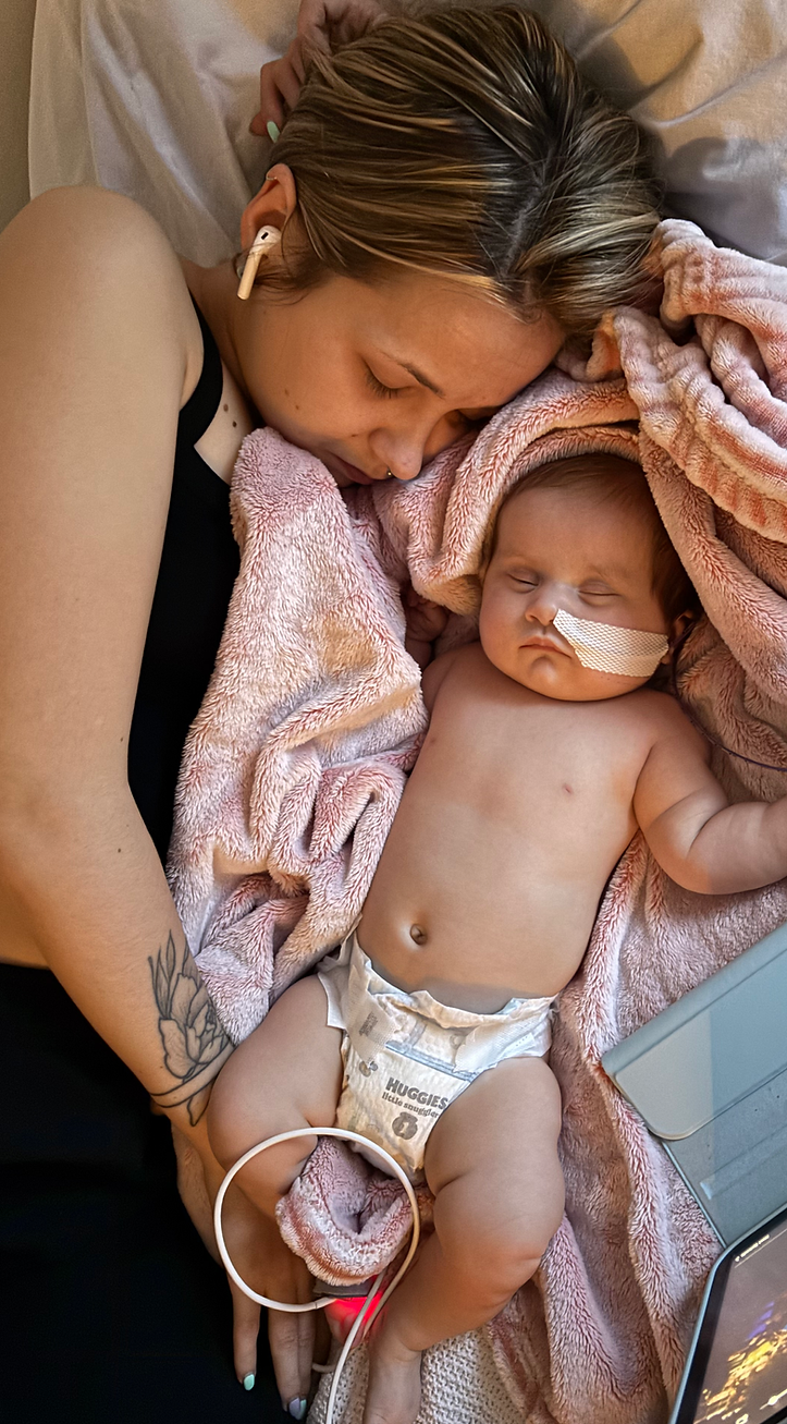 Mother and baby resting together, baby with nasal tube