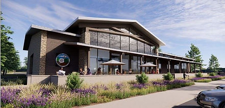 The New Moorpark City Library with glass windows, in front are sitting area with umbrellas and plants. Green trees in the background.